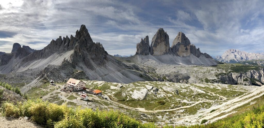 A panoramic view captures the rugged allure of the Three Merlons against a mountainous backdrop.