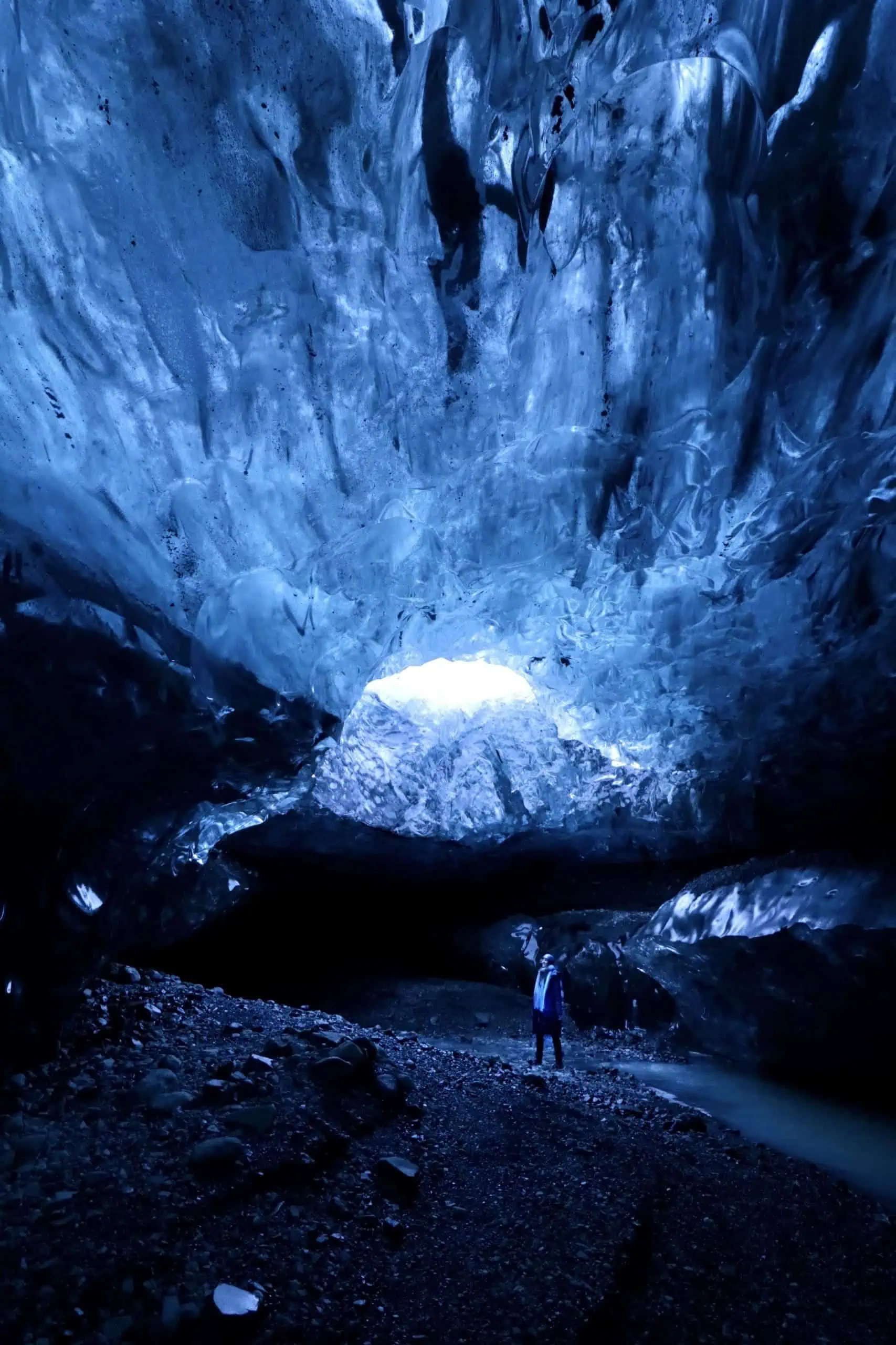 Blue Coloured Glacier Ice Cave in Iceland with light shining throug a hole in the ceiling